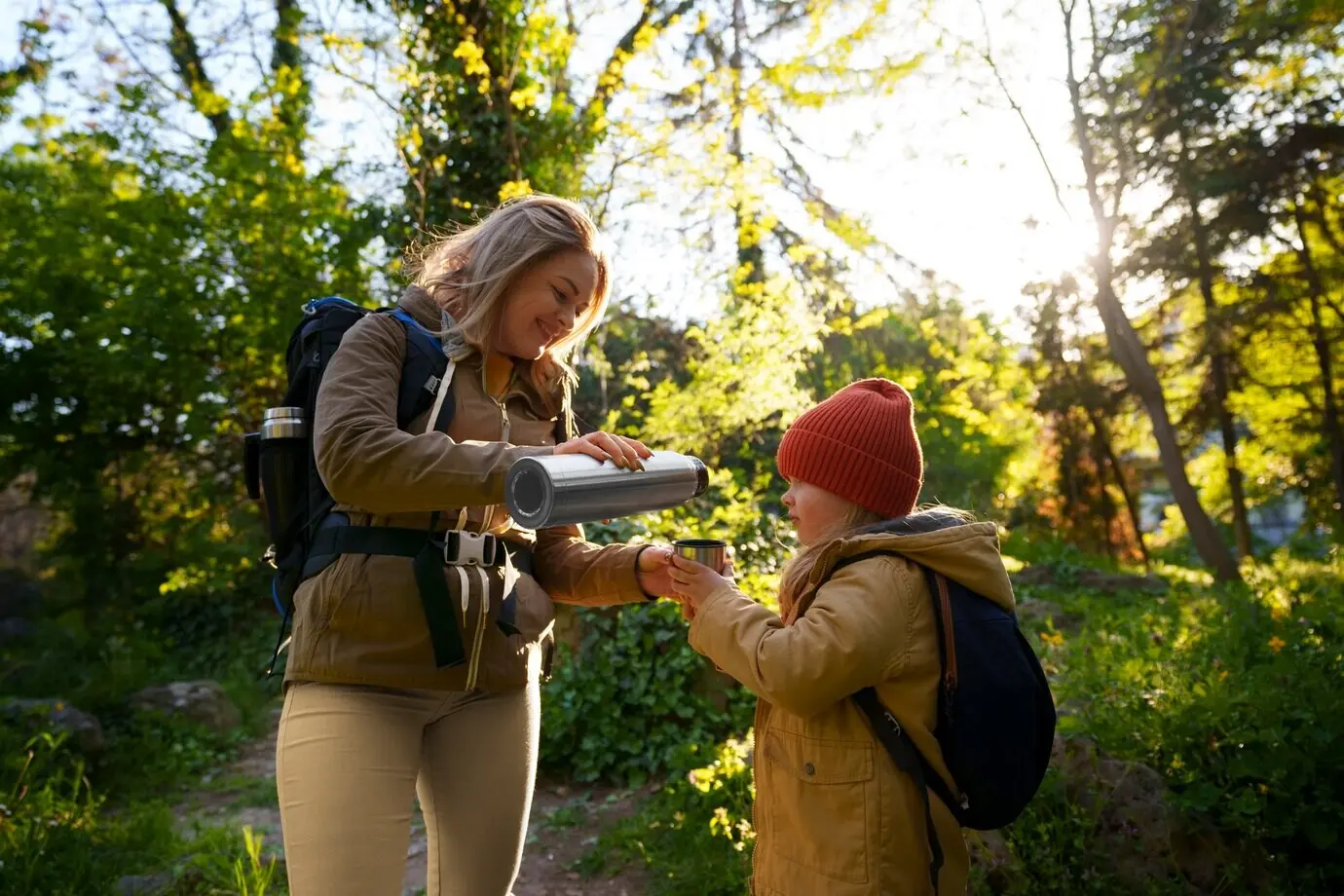 A side view of a woman and a girl exploring nature.